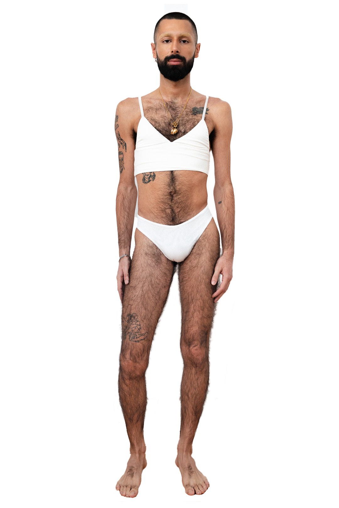 ENBY person wearing a white tucking underwear compression gaff with a cheeky cut and white bamboo bralette, photographed from the front.