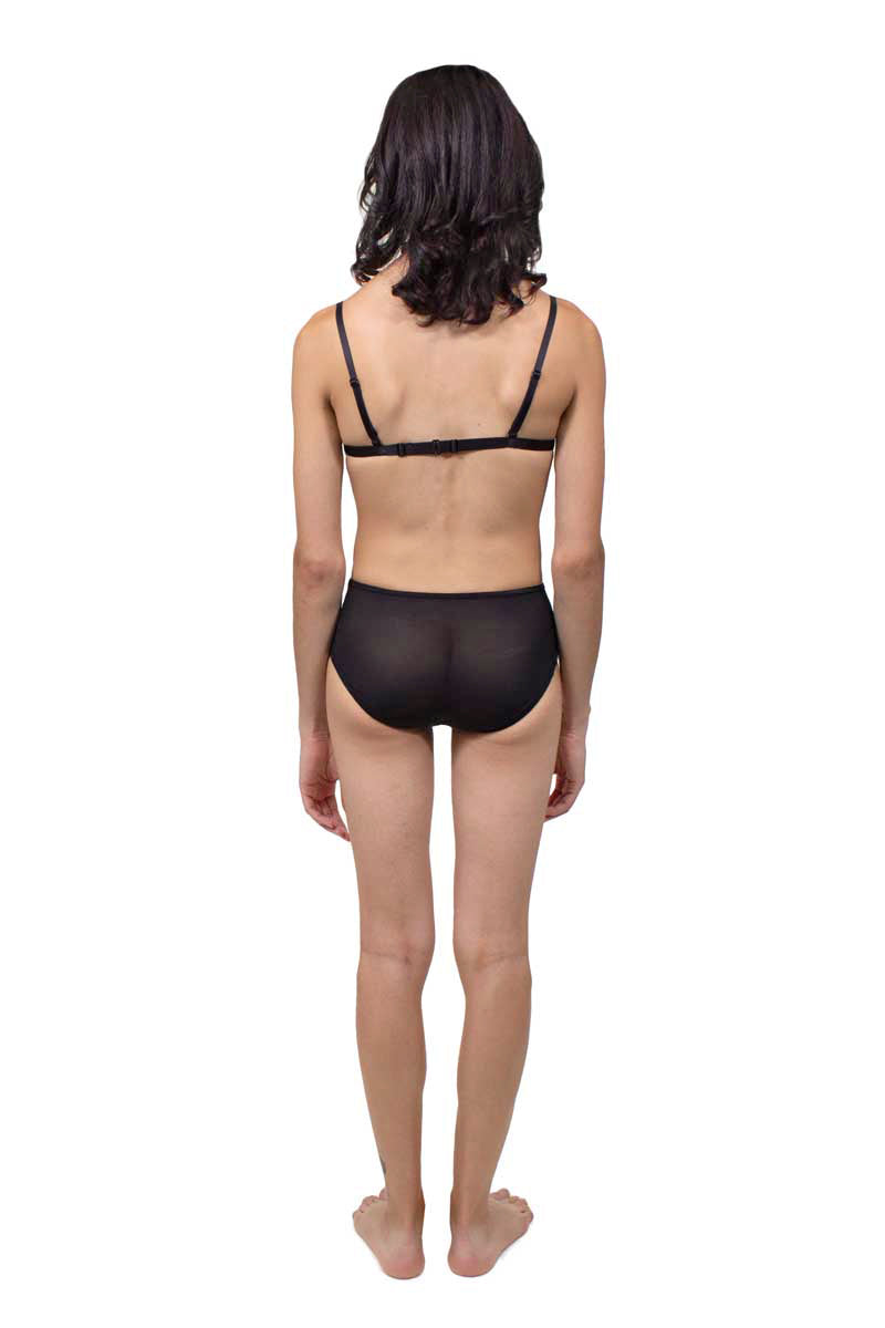 Transfemme person wearing a black tucking underwear compression gaff and bamboo bra, photographed from the back.