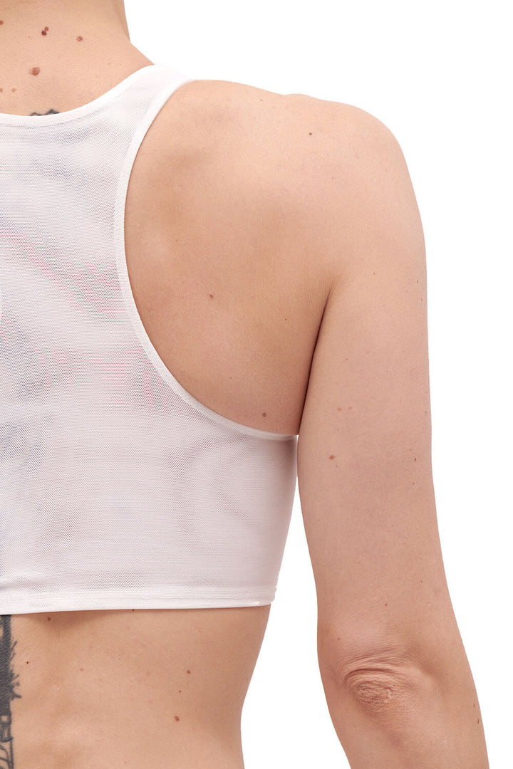Detail of the back of a white mesh chest binder, shown on a person.