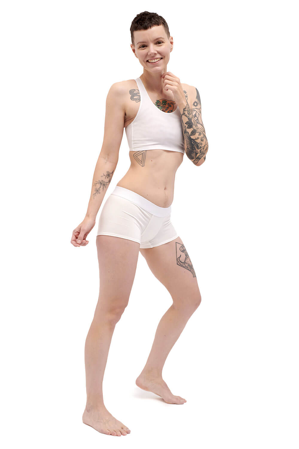 Petite person wearing a white racerback side-open chest binder made from breathable mesh, photographed from the side.