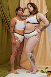 A transgender and plus size lingerie model wear the sustainable bamboo thong undie. One is wearing the custom bra and panty sets, one is wearing the matching gender affirming chest binder